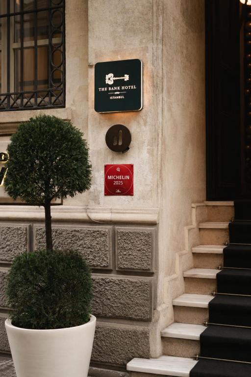 a sign on the side of a building with a plant at The Bank Hotel Istanbul, a Member of Design Hotels in Istanbul