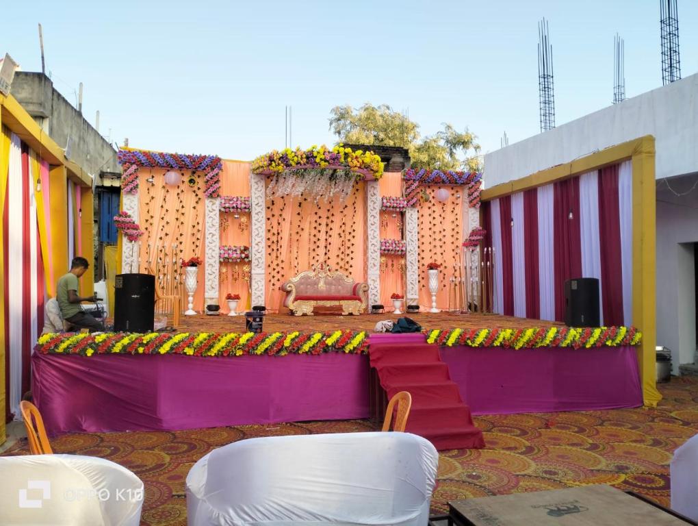 a stage with purple and pink barriers and flowers at Hotel ashtha inn in Gaya