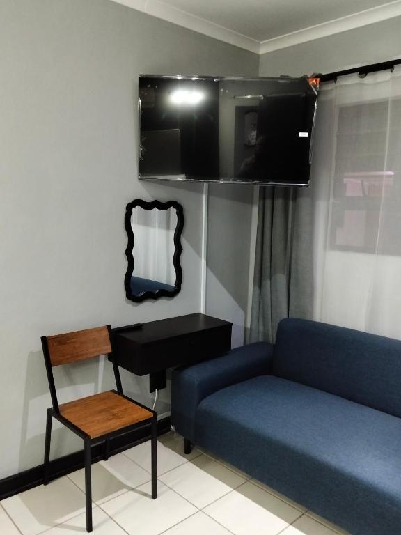 a living room with a blue couch and a mirror at Sunflower Acres in Kimberley