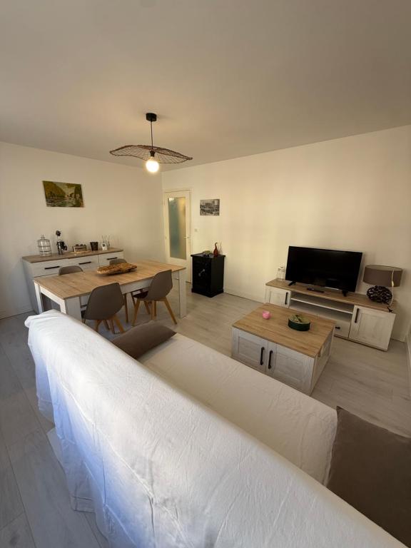 a living room with a large couch and a table at Les 3 Pigeons in Narbonne