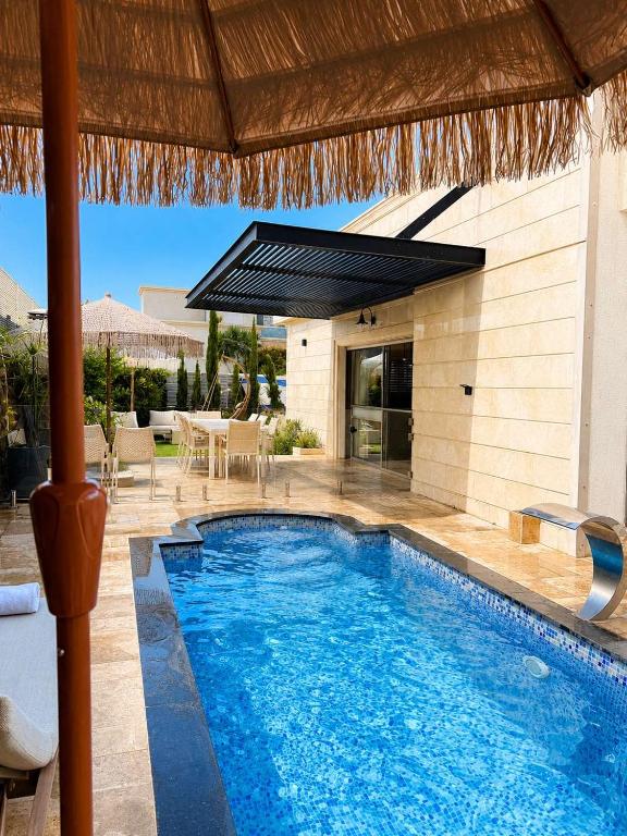 a swimming pool in front of a house at Villa Naama in Qasrîne