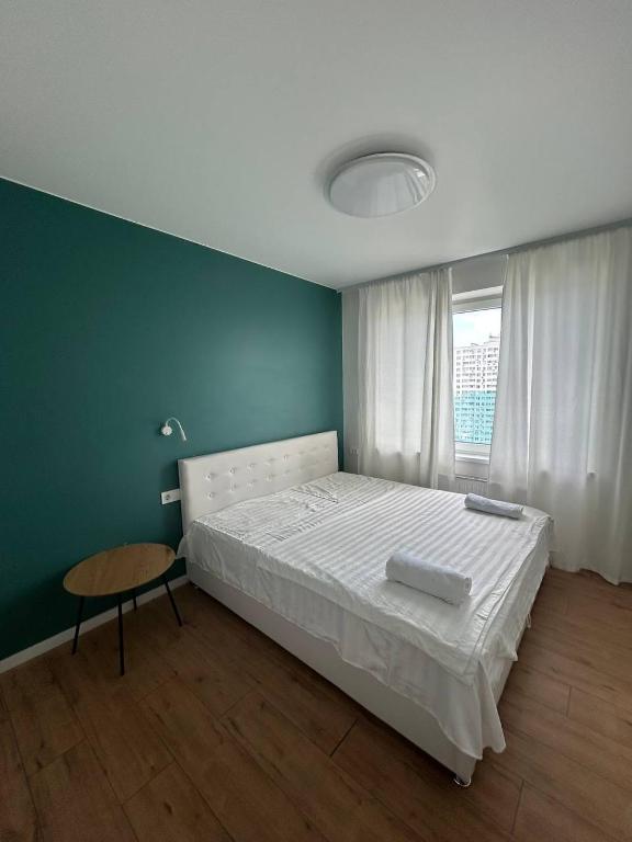 a bedroom with a white bed and a table at Апартаменти La Familia в Одеський Бульвар - Od 433 in Teremki