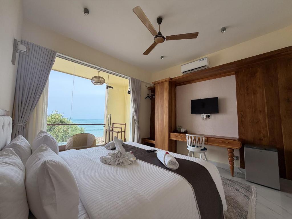 a bedroom with a large bed with a view of the ocean at Mora Mila in Arugam Bay