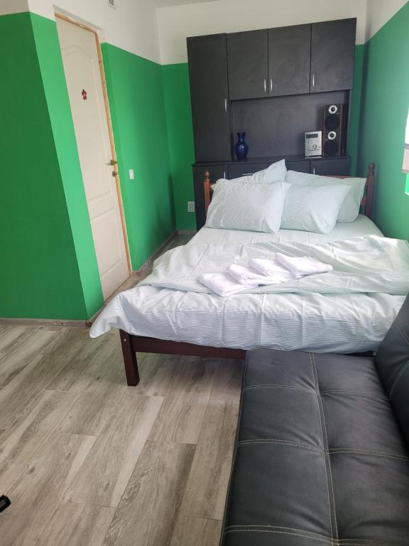 a bed in a room with a green wall at Căsuța de vacanță in Eforie Sud
