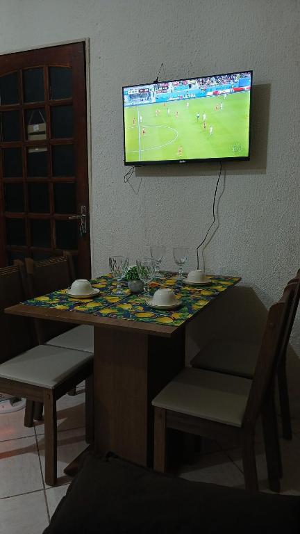 a table with a tv on a wall with a soccer game on it at Casa Napolitana in Uruguaiana