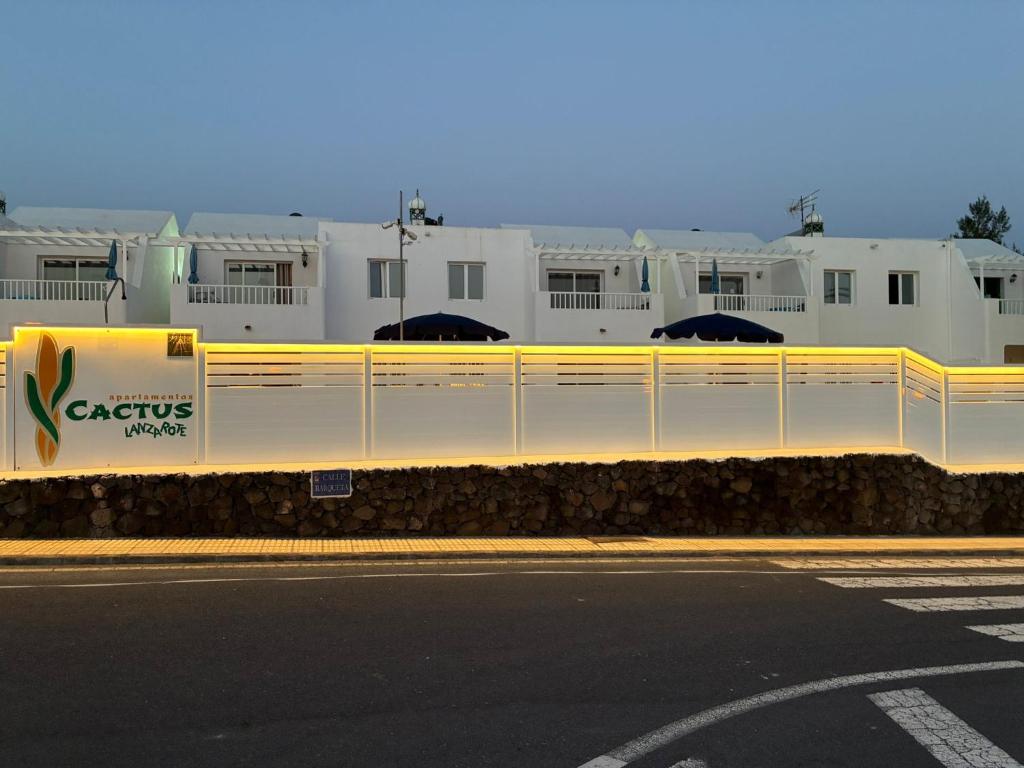 a white fence next to a street with buildings at Cactus in Puerto del Carmen