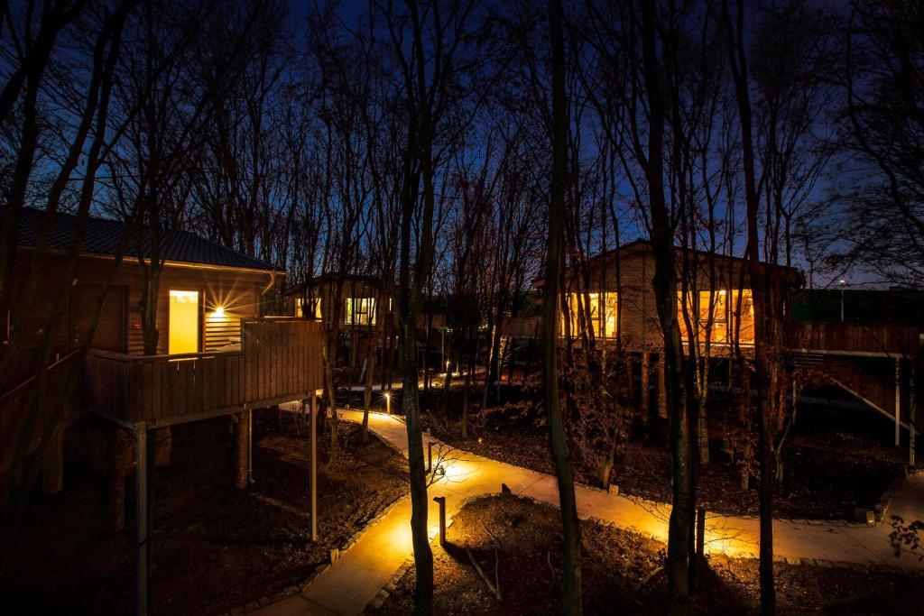 a night time view of a tree house with lights at Hotel Fire & Ice Düsseldorf/Neuss in Neuss