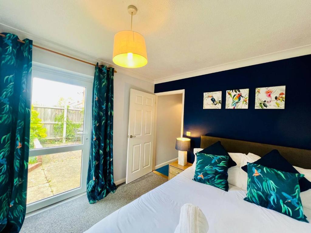 a bedroom with a bed and a large window at Bright & Sociable Home with Garden Retreat in Capel Saint Mary
