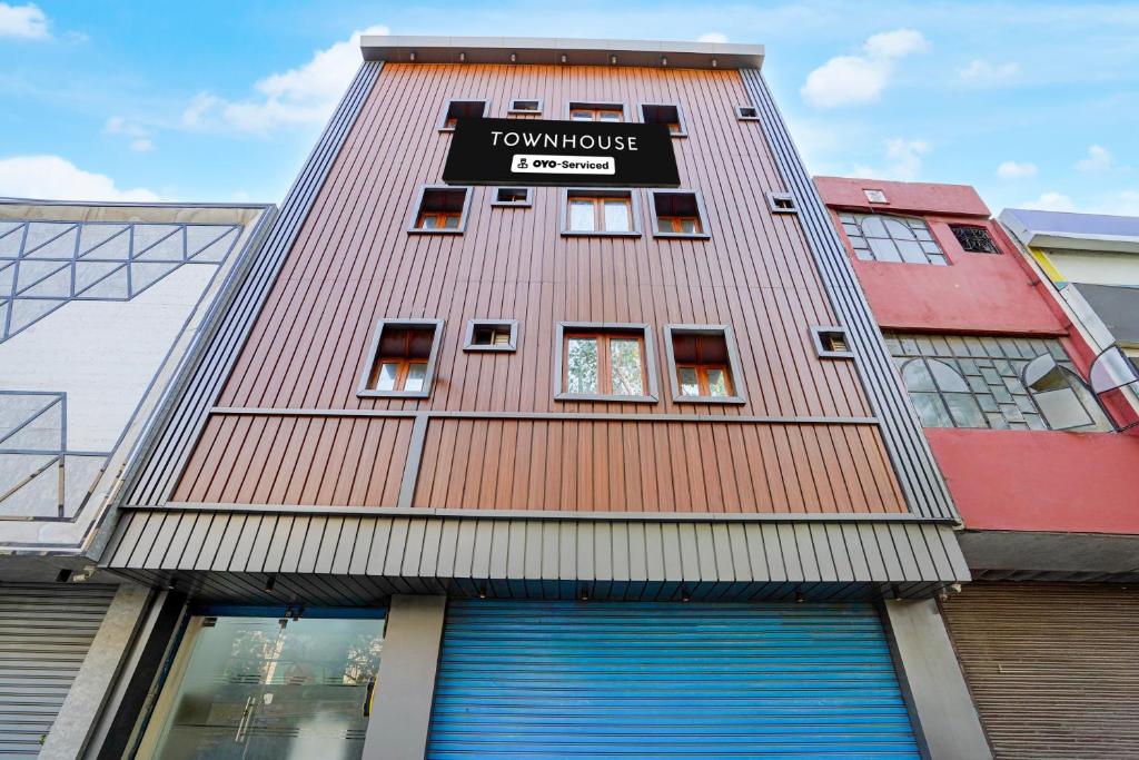a tall red building with a sign on it at Super Townhouse Krishna Nagar Metro Station in New Delhi