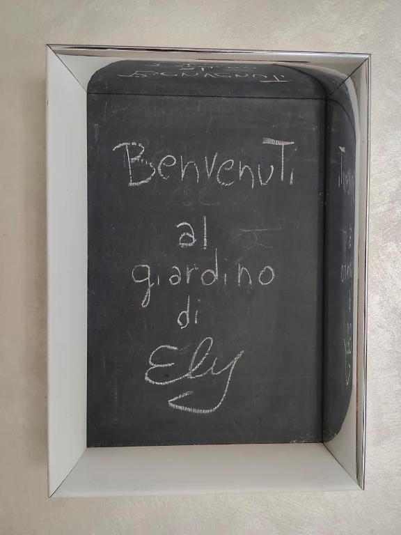 a chalkboard with the words reinventing a garden of joy written on it at Il giardino di Ely in Senigallia
