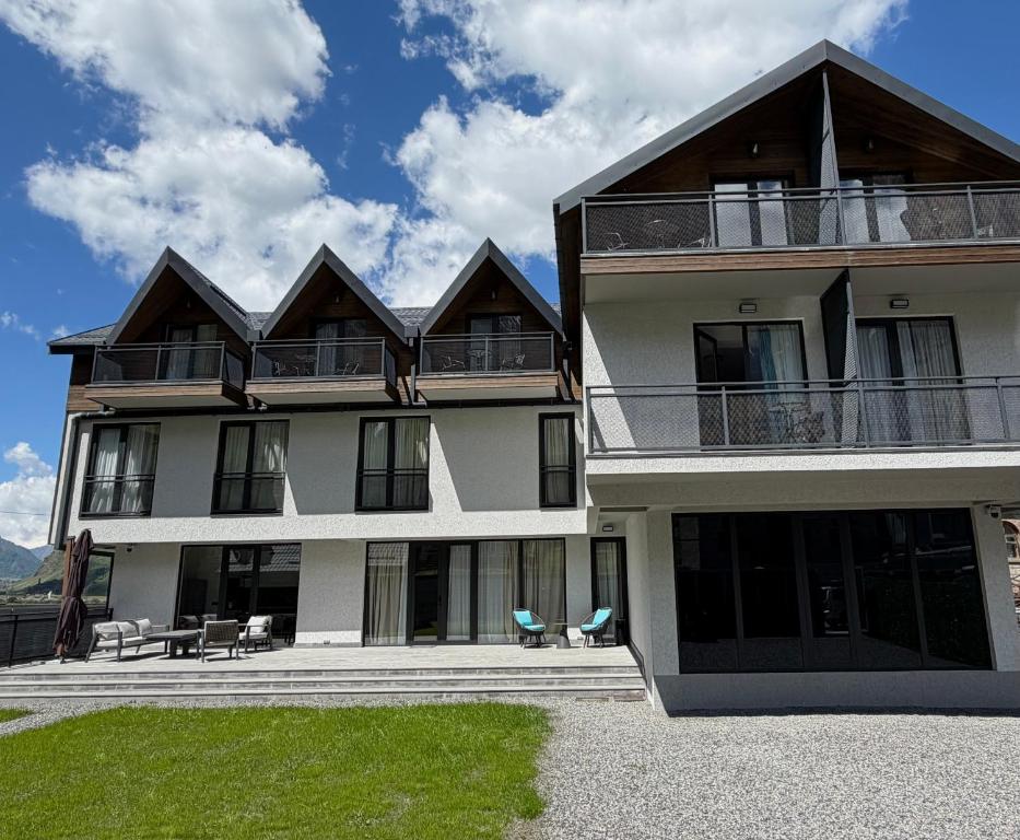 a large building with chairs and tables in front of it at Oli Home in Kazbegi