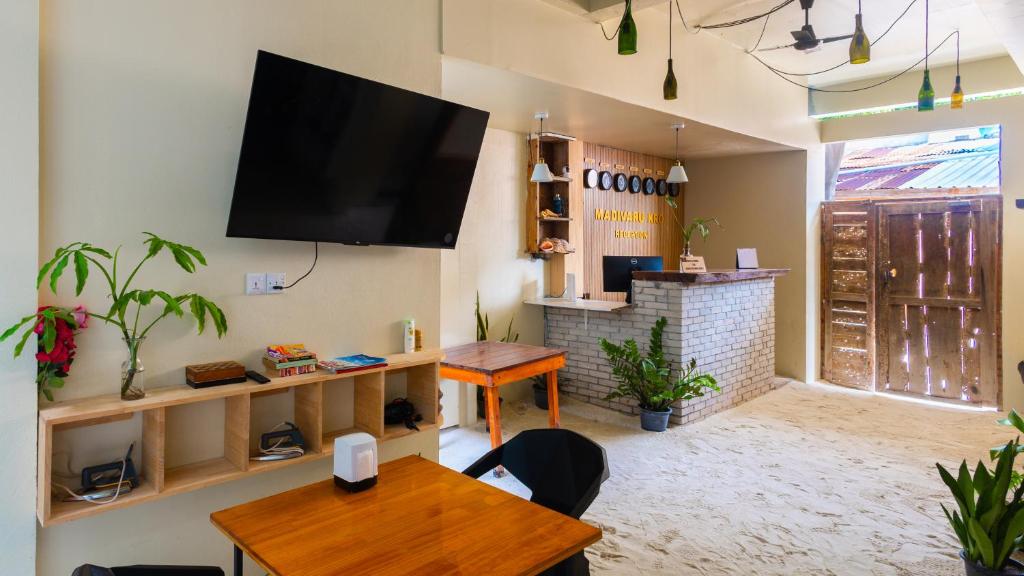 a living room with a flat screen tv on the wall at Madivaru Kro in Rasdhoo