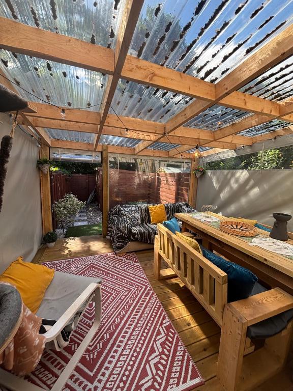 a patio with a wooden pergola and a table at Cosy home in Edinburgh in Edinburgh
