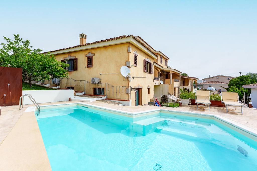 a house with a swimming pool in front of a house at Sa Murta Bianca Guesthouse Budoni in Budoni