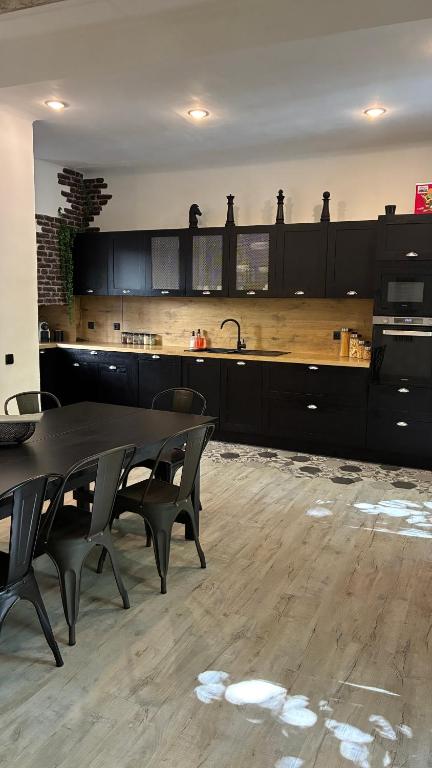 a kitchen with a table and chairs and a sink at Maison de ville exceptionnelle in Carpentras