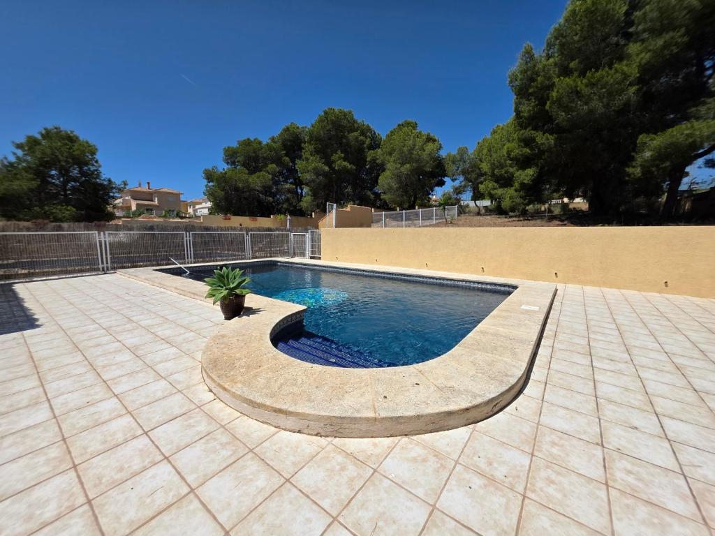 a swimming pool with a potted plant on a patio at Chalet Paradise of the Mediterranean in La Nucía