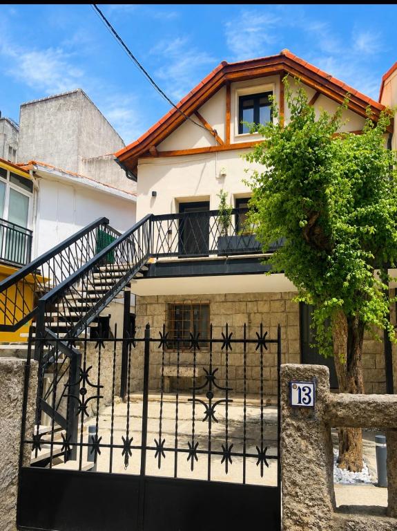 a house with a black gate and a staircase at La casa Suiza in Cercedilla