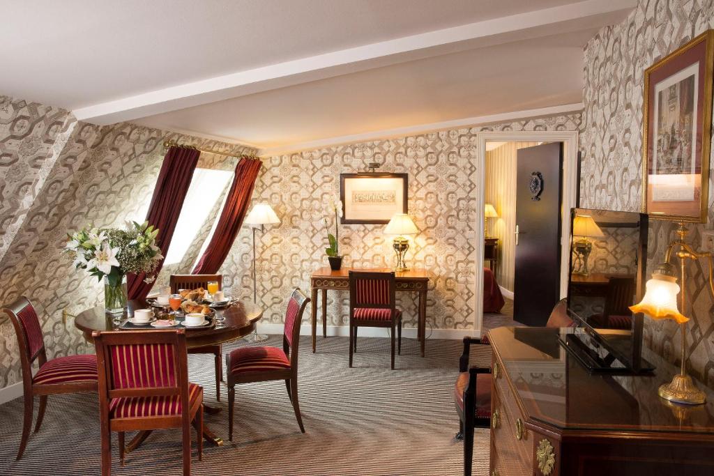 a living room with a table and chairs and a dining room at Hotel Residence Des Arts in Paris