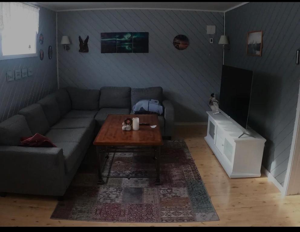 a living room with a couch and a coffee table at Komfortabel overnatting på veien mot Nordkapp in Kolvik
