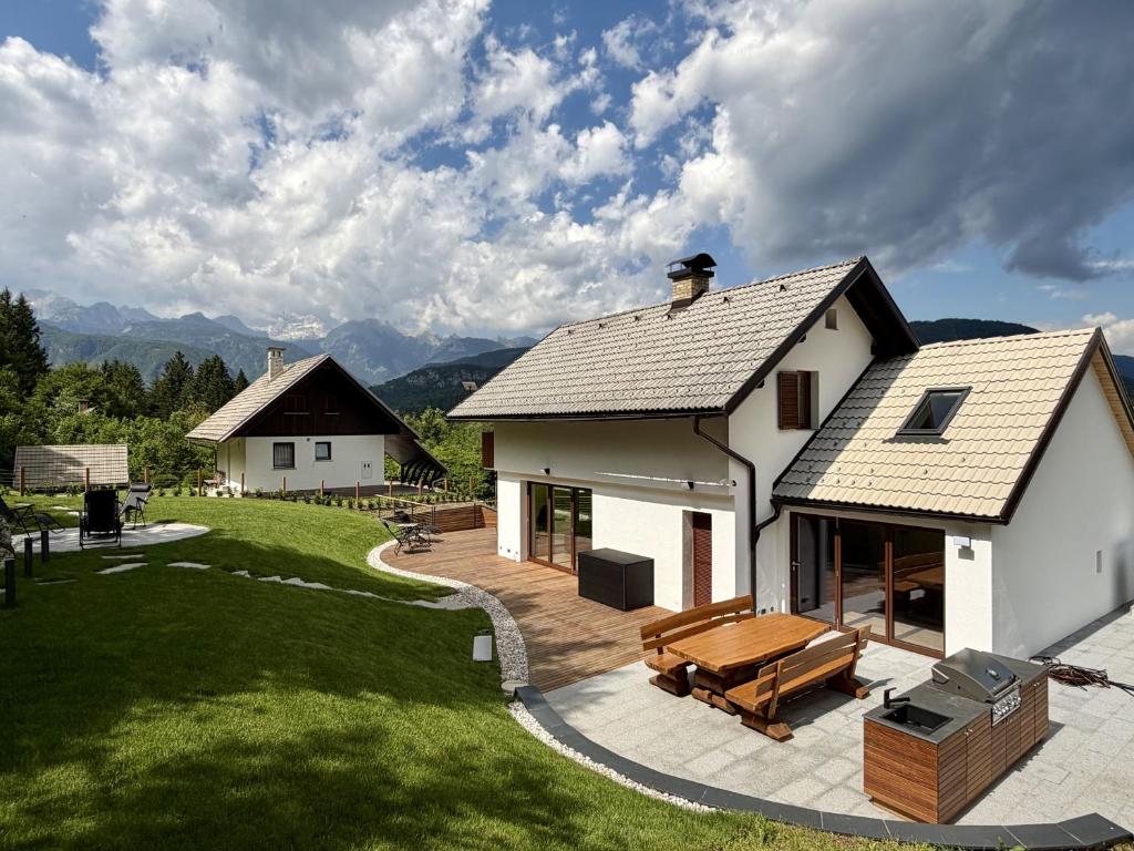 a white house with a deck and a bench at Villa Belica in Bohinj
