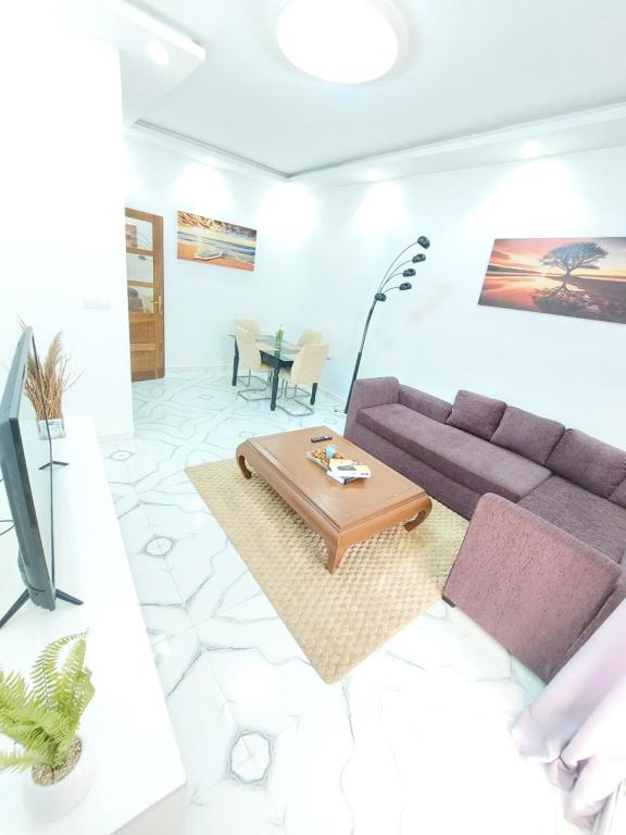 a living room with a couch and a table at Horizon Bleu Cozy prés de la Plage avec Balecon in Dakar
