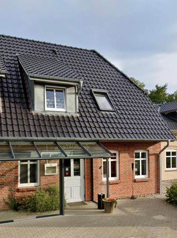 a red brick house with a black roof at Alpenstube Ockholm in Ockholm