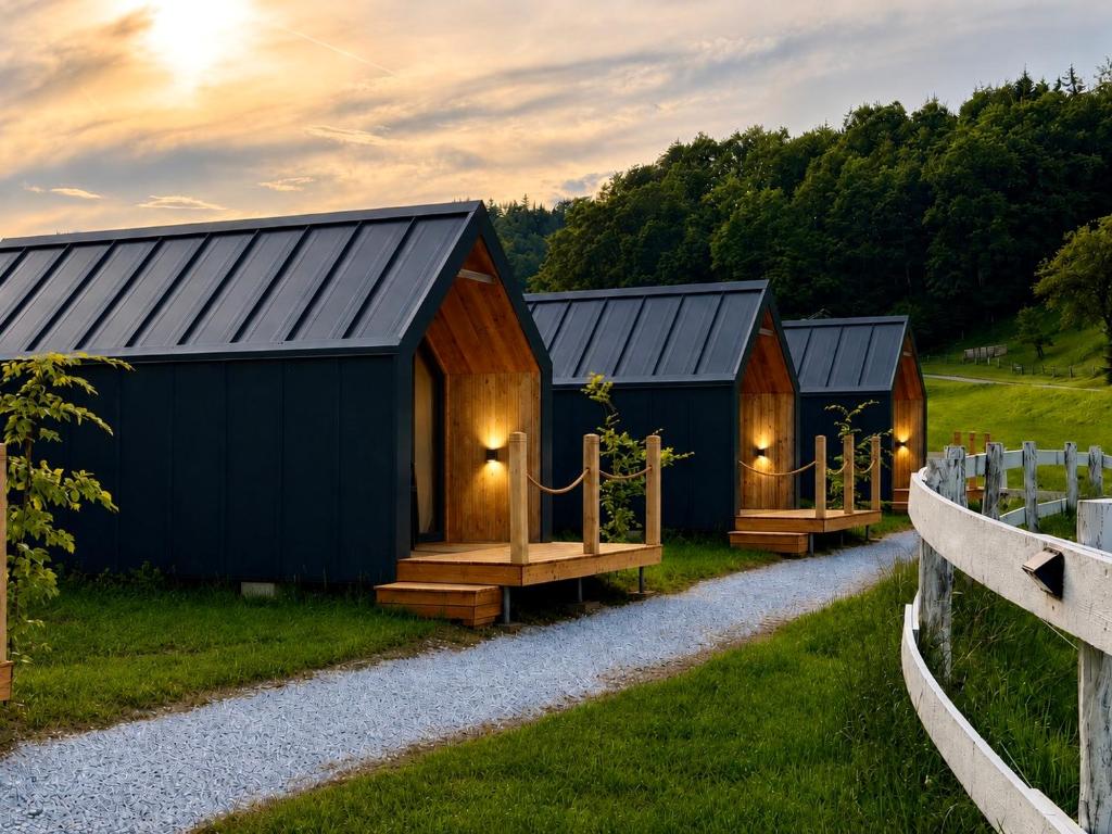 a row of huts in a field with a gravel road at Bela Resort - Glamping in Motnik