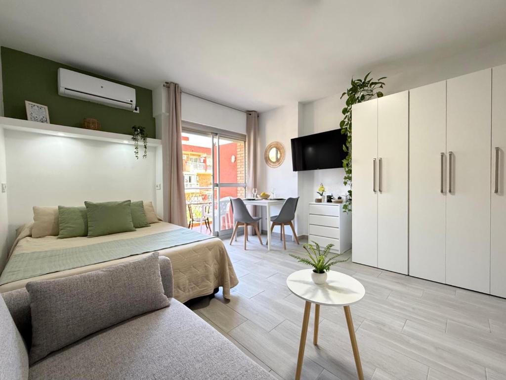 a bedroom with a bed and a living room with a table at Hercules Cozy Studio - City Center and Near Beach in Benalmádena