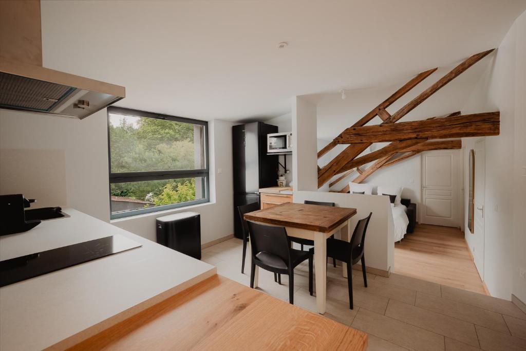 a kitchen and dining room with a table and a bed at L'annexe de Bresteau in Beillé