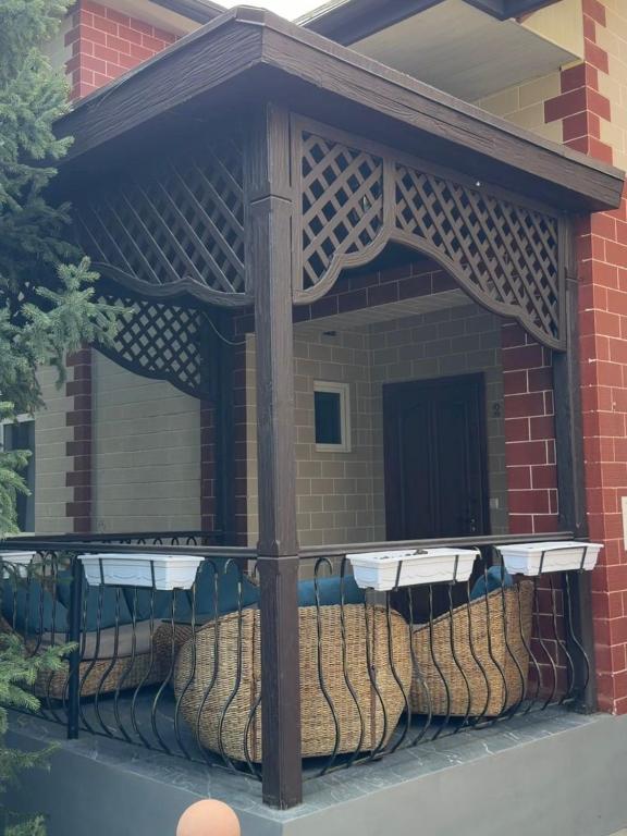 a gazebo with a fence in front of a building at Солнышко VIP 1 in Chok-Tal