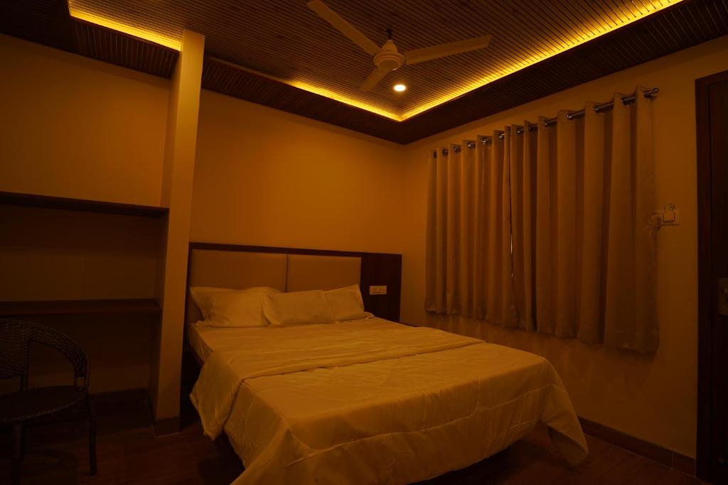 a bedroom with a bed and a ceiling fan at khopoli resort in Khopoli
