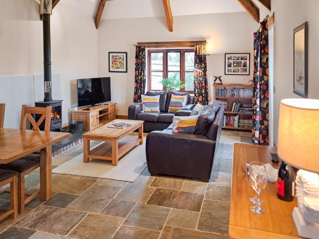 a living room with a couch and a tv at Jacks Barn - Hssu in Welcombe