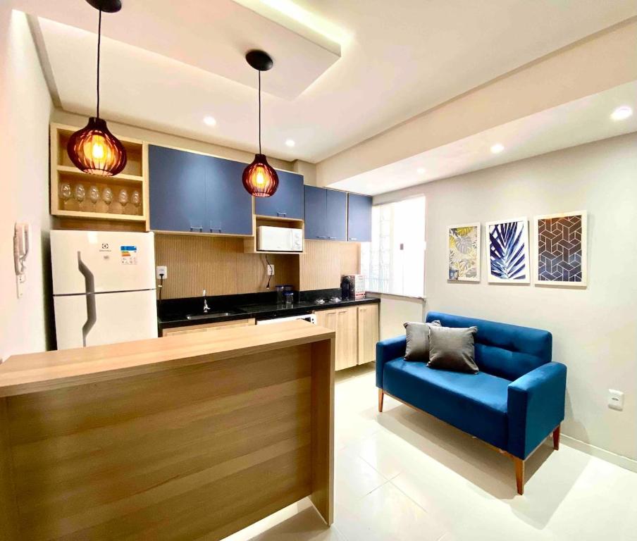 a living room with a blue couch and a kitchen at 302 · 302 2qtos Encantador com garagem grátis in Belém