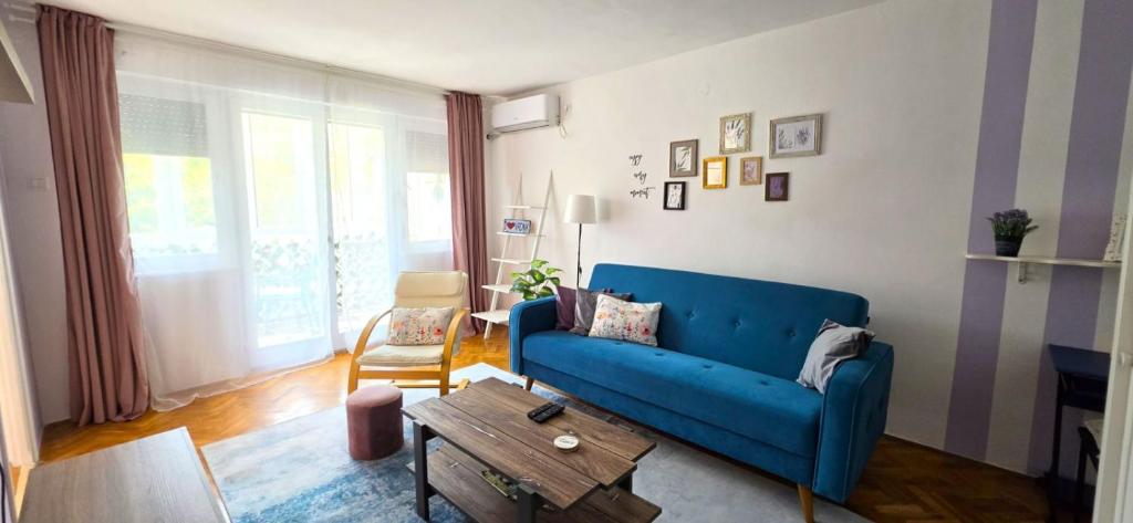 a living room with a blue couch and a table at Apartman Lavanda in Vrdnik