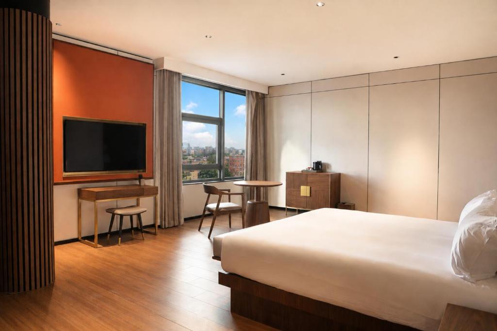 a hotel room with a bed and a desk and a television at Hotel Hualton in Alcobendas