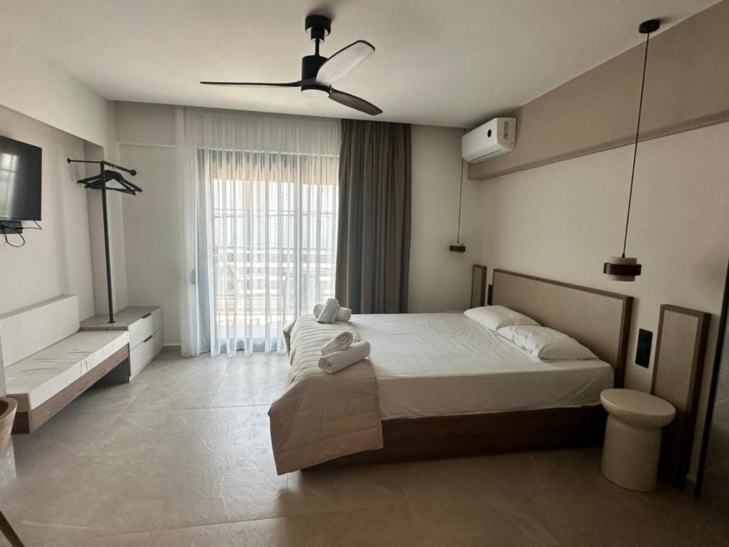 a bedroom with a bed and a ceiling fan at 7 Suites in Skiathos