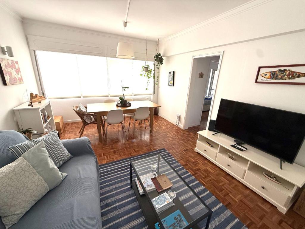a living room with a couch and a tv at Estoril 2 bd by the Beach in Estoril
