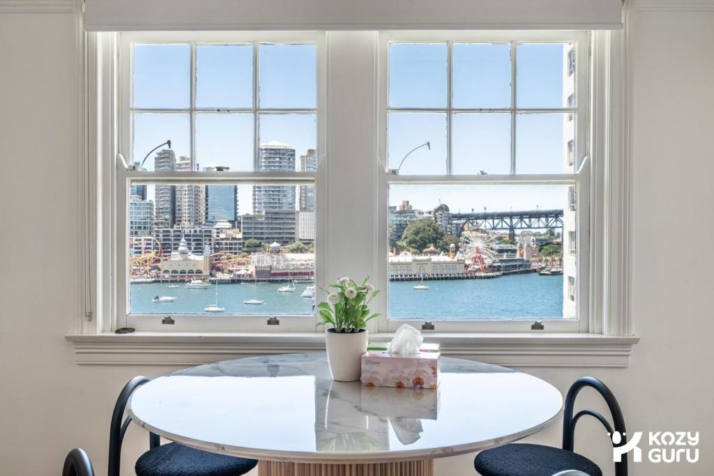 a white table and chairs in a room with a window at KozyGuru | MacMahons Point | Harbour Hideaway in Sydney