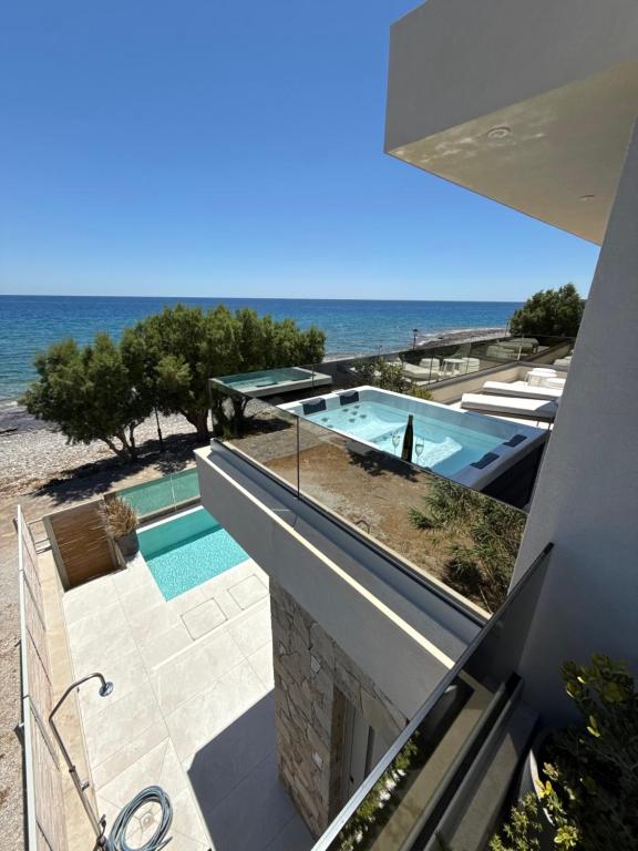 a house with a swimming pool next to the ocean at Luxury Villa Asana in Koutsourás