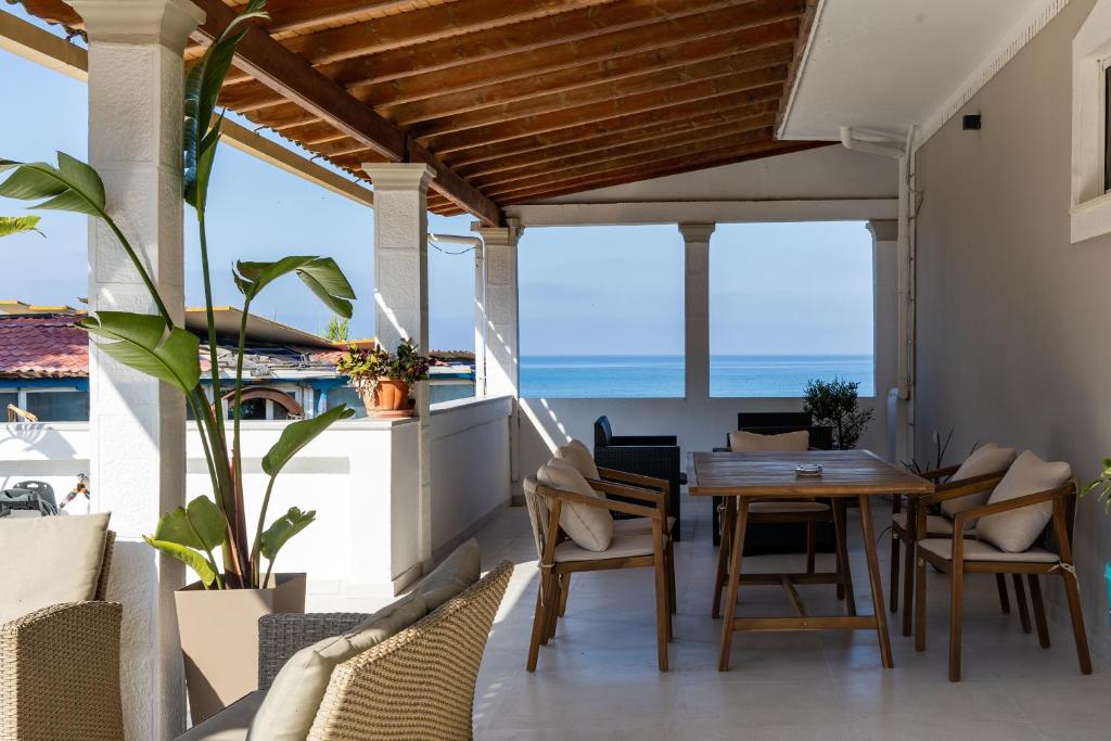 a dining room with a table and chairs on a balcony at Marea Blue Seaview Apartments of Santa Barbara in Marathias
