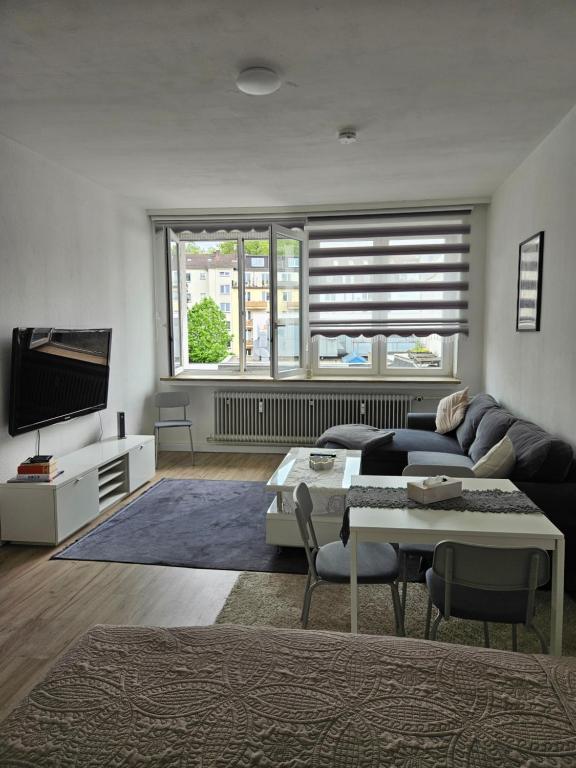 a living room with a couch and a tv at City Base Dortmund in Dortmund