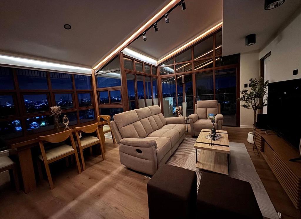 a living room with a couch and a table at Casa Attika - Modern Glasshouse with Skyline Views in Antipolo
