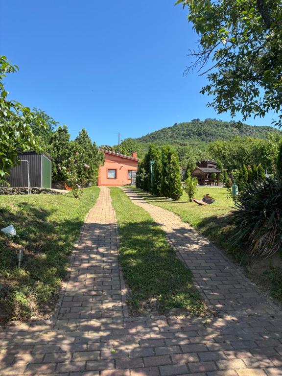 a brick road with a house in the background at TanúHill Garden in Tapolca