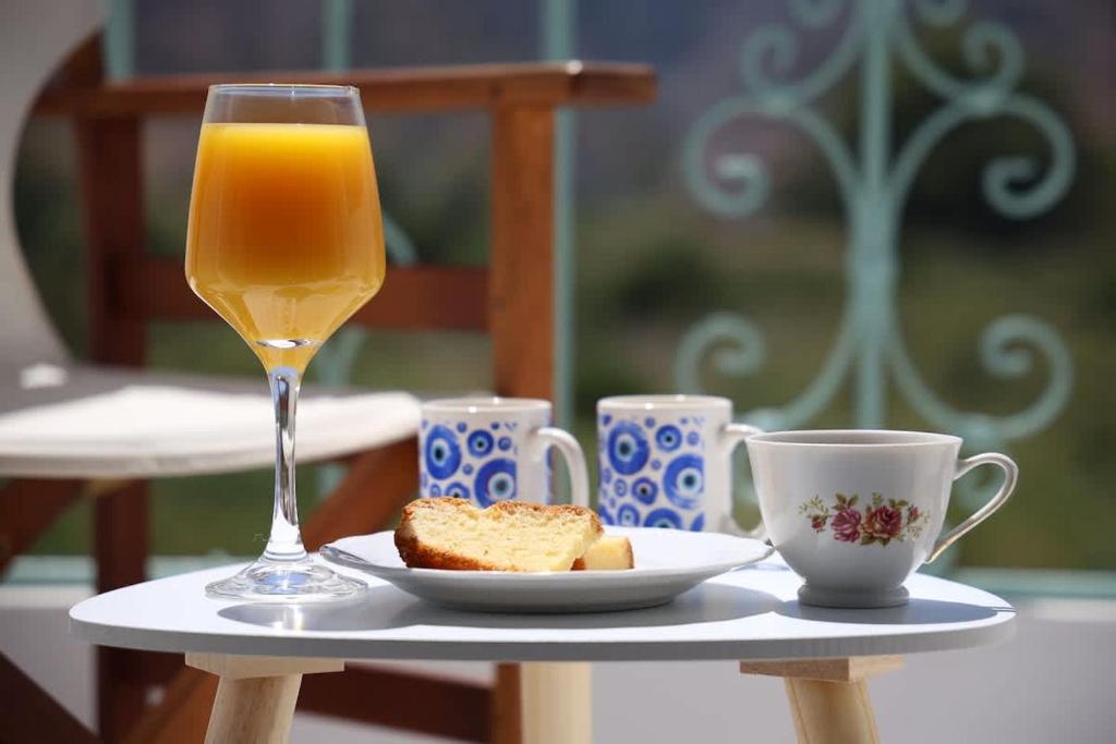 a glass of orange juice and a plate of bread and cups at Apartment Simply 206 in Gázion