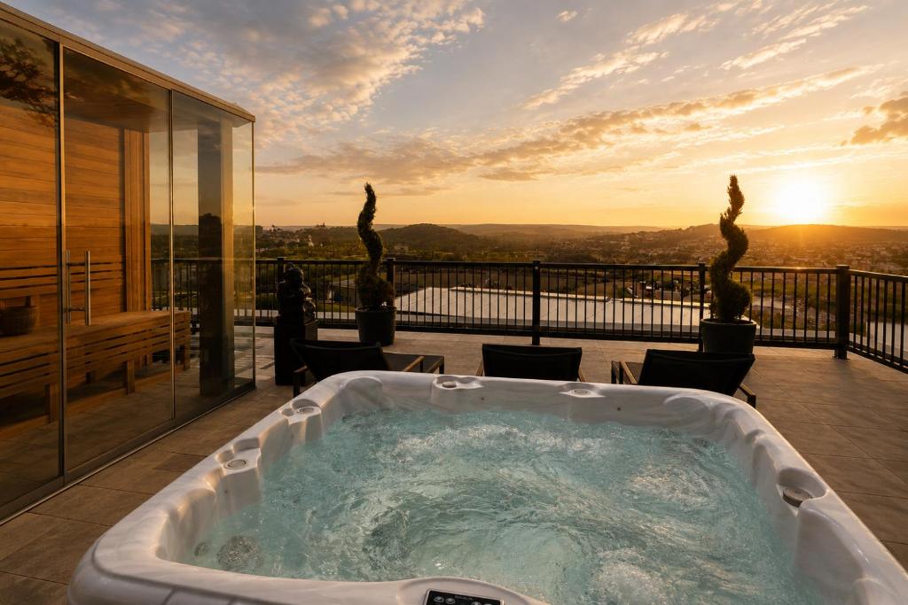 a jacuzzi tub on a balcony with the sunset at Luma Hotel Spa&Fitness in Fulda