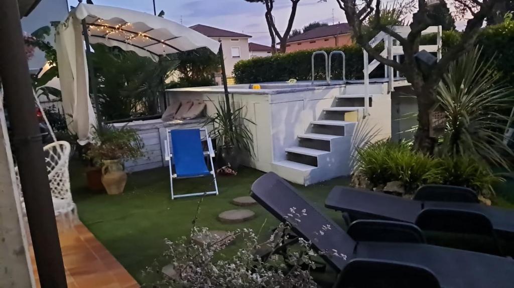 a backyard with a swimming pool and a blue chair at Sakura B&B Franciacorta in Cologne