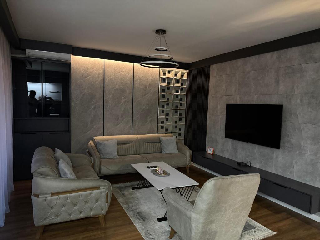 a living room with a couch and a table at J K E apartments in Prishtinë