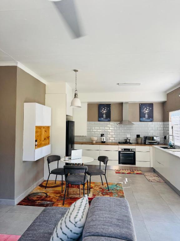 a kitchen with a table and chairs in a room at The Leafy Stay in Rundu