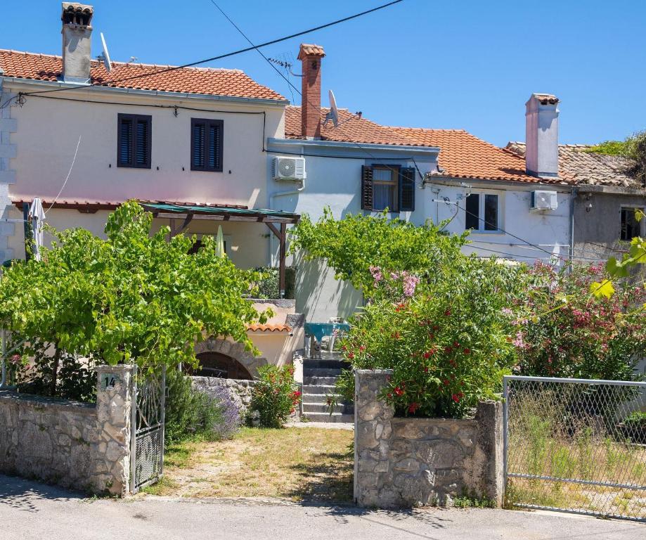 a white house with bushes in front of it at Kuca za odmor Kornic in Kornić