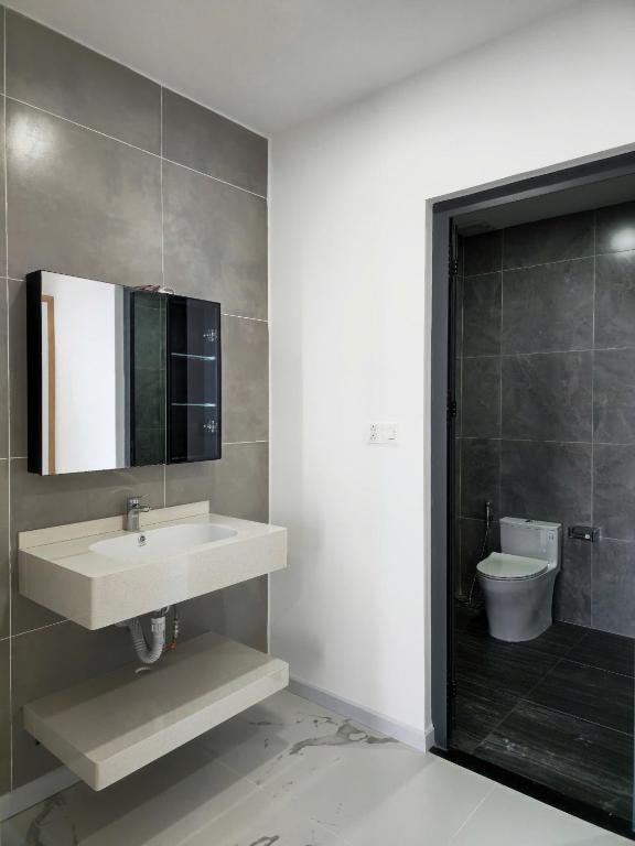 a bathroom with a sink and a toilet and a mirror at Resort Long Hải in Binh Chau